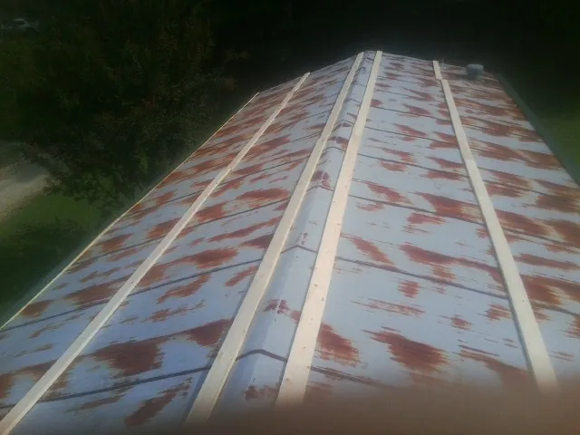 Rusted metal roof panels with new wood purlins before replacement — Storm Damage Roof Repair in Williamsfield by Roofing Brothers