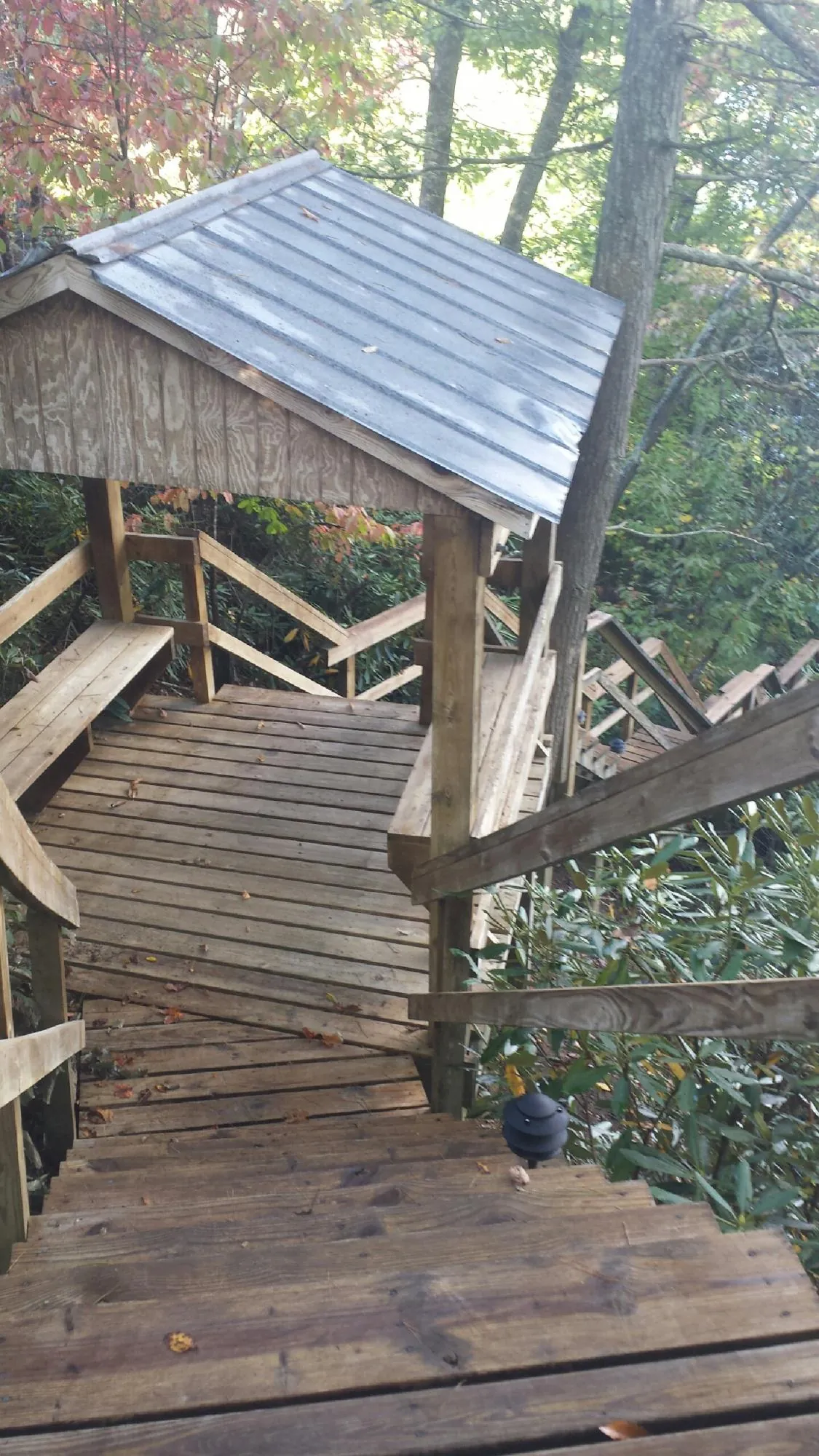 Metal roofed shelter over wooden steps on a wooded walkway — Skylight Repair & Installation work by our crew in Williamsfield